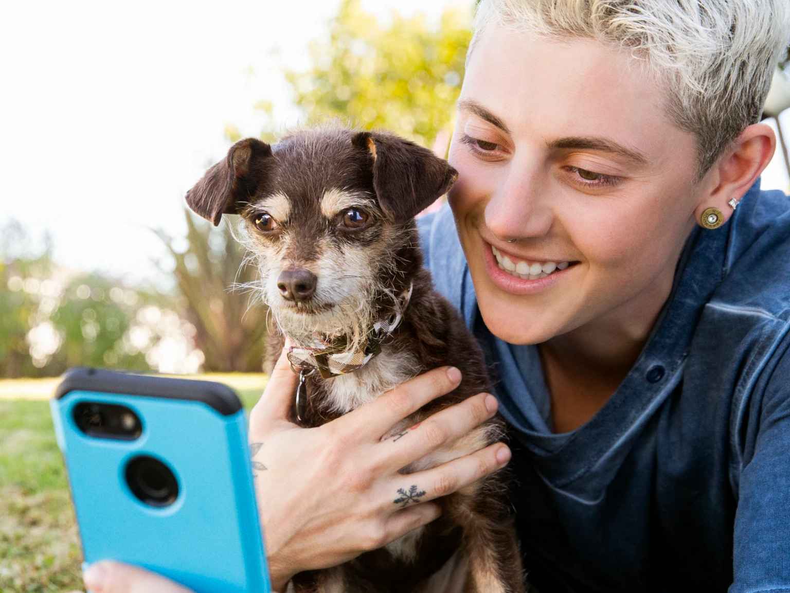 Un dueño y su cachorro con un teléfono inteligente.