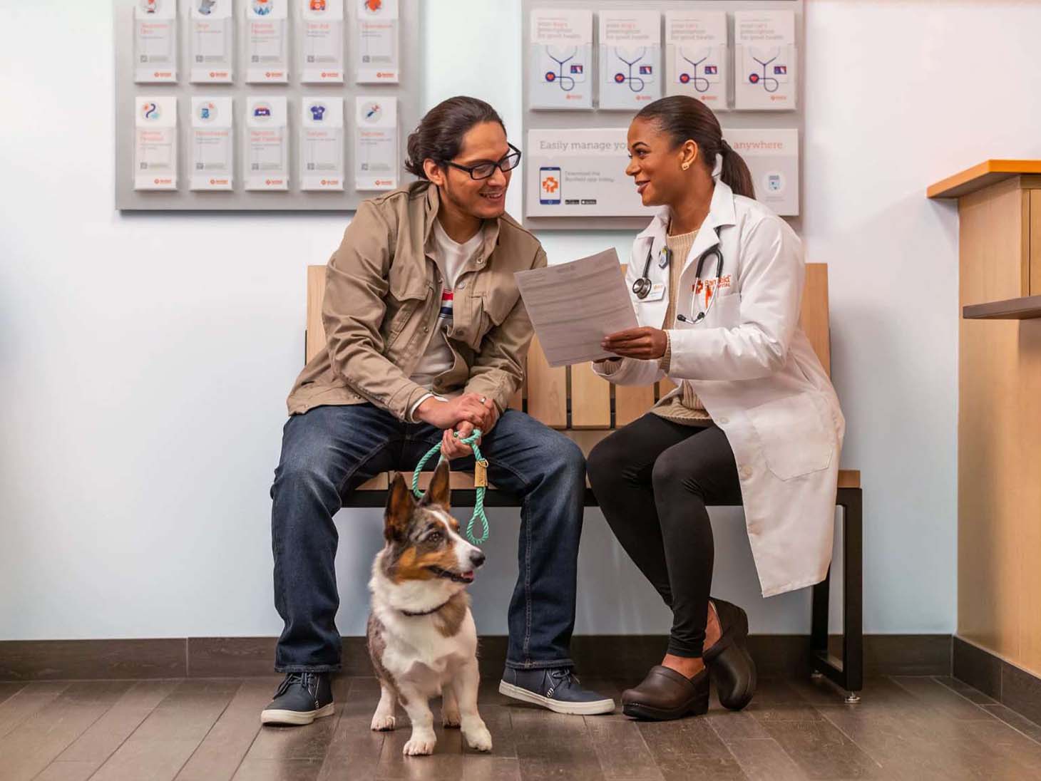 un dueño con su perro que habla con una médica veterinaria