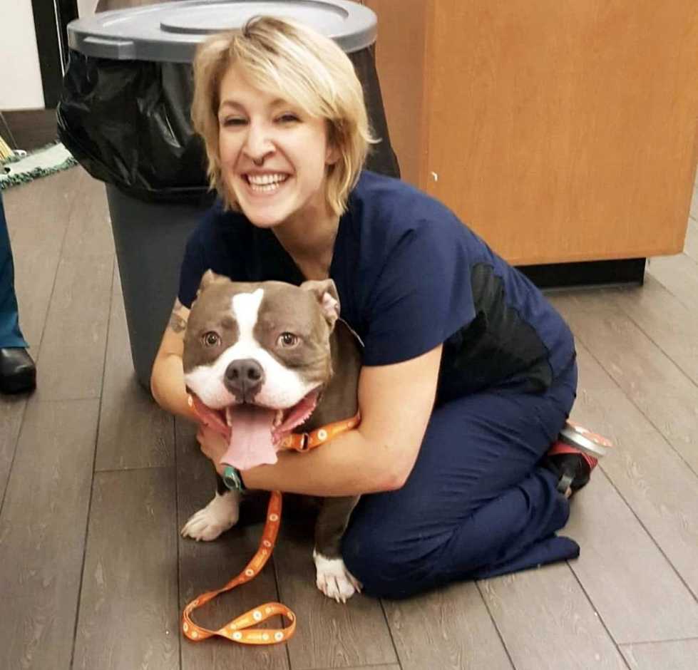 Una joven veterinaria abrazando a un perro en Banfield Pet Hospital
